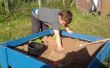 A Sand Box avec couvercle fait des planches traitées clôture. 